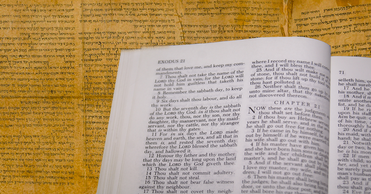Picture of an open Bible in front of the Dead Sea Scrolls.